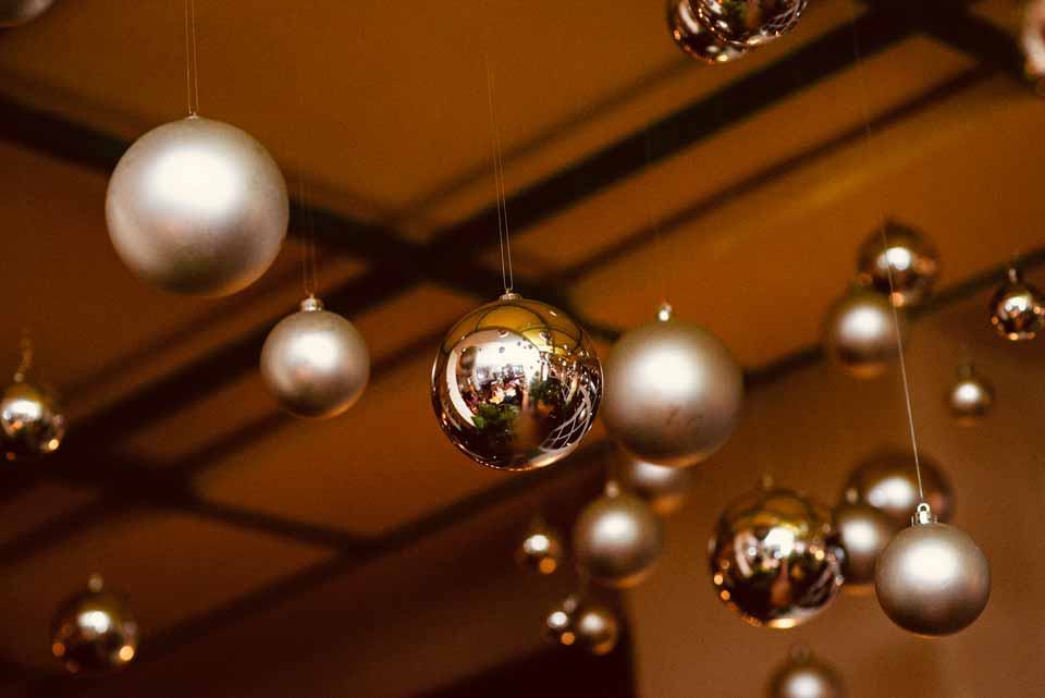Silberne Weihnachtskugeln hängen von der Decke und reflektieren den Gastraum des SUPER im romantischen Licht.